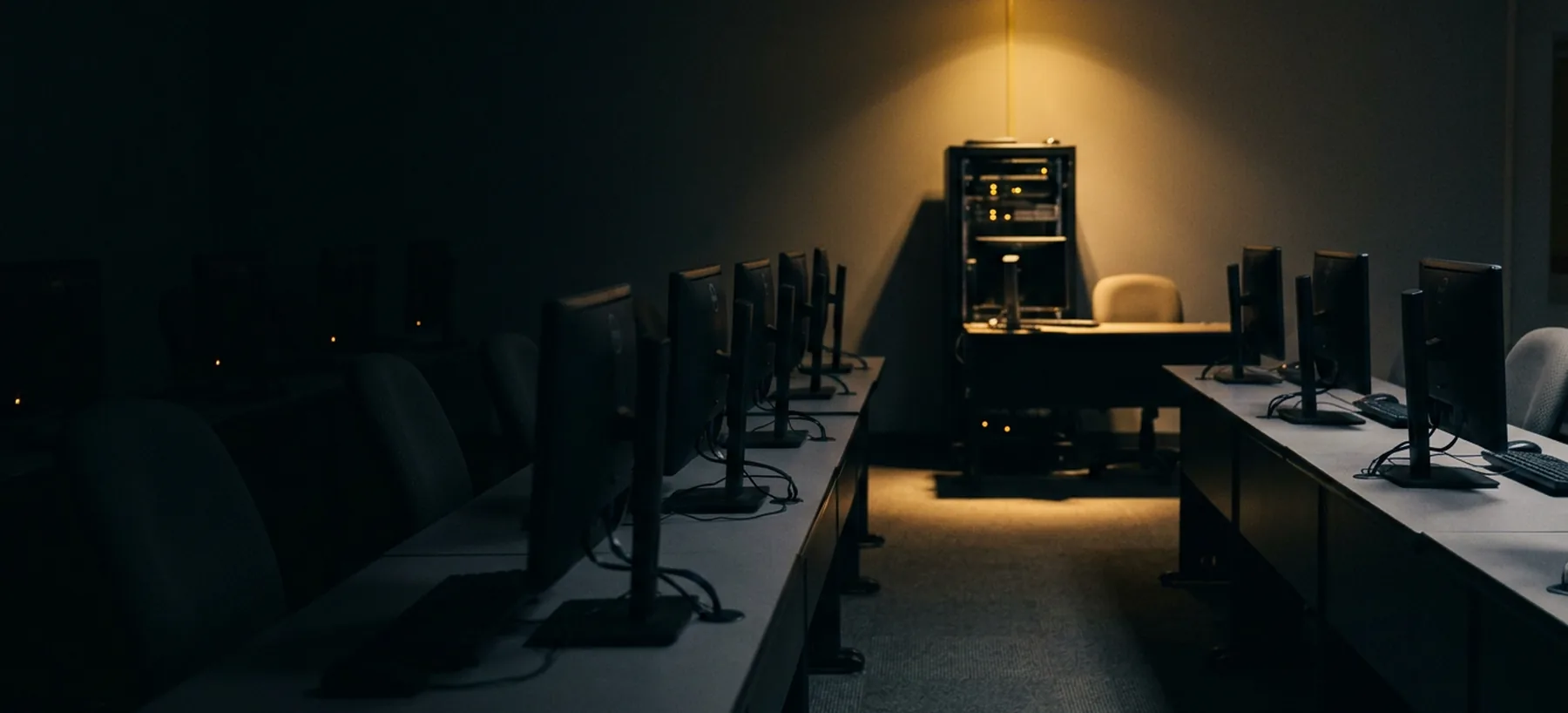 An empty cybersecurity training room with rows of workstations