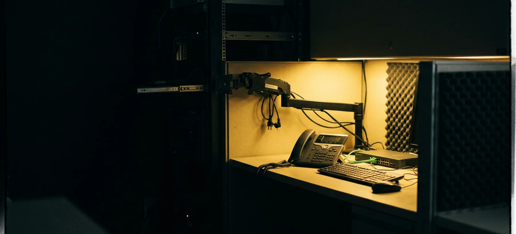 A single lit desk in an otherwise dark operations room